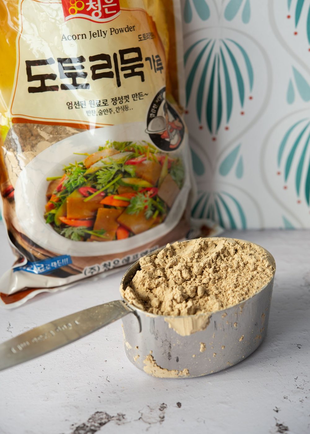 Korean acorn jelly powder (acorn starch) in a cup.