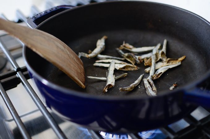 Toasting dried anchovies in a pot.
