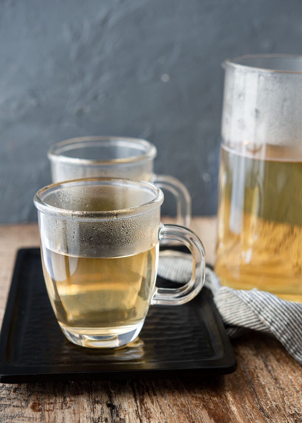 Steaming Korean barley tea is presented in glass cups on a tray.