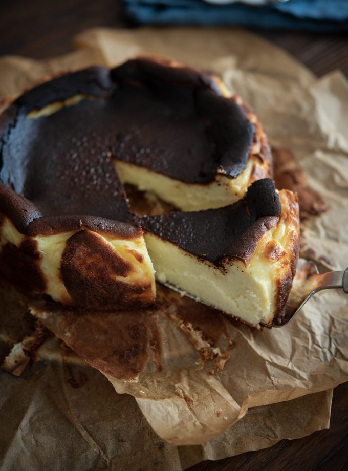 A slice of basque cheese cake shows velvety moist savory texture.
