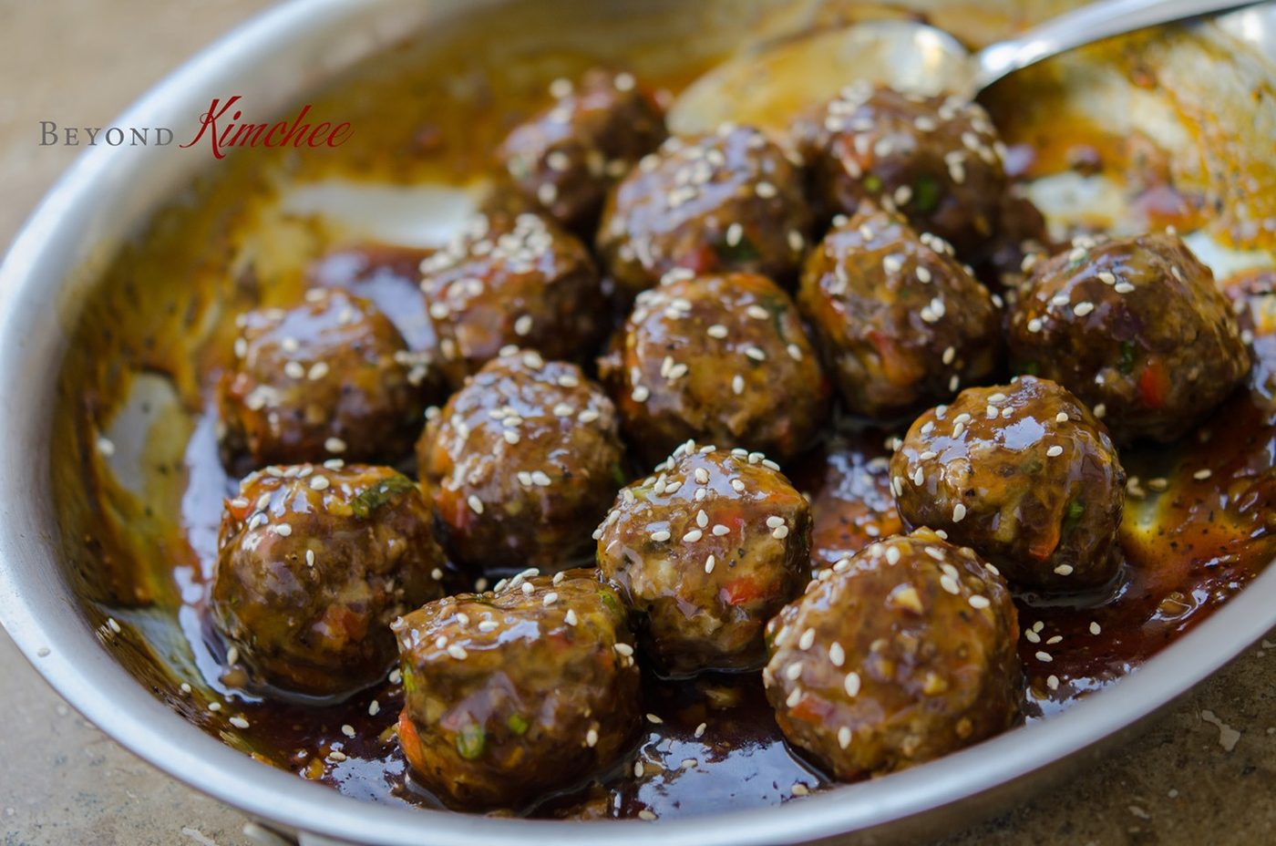 Sweet and savory meatballs coated in pineapple soy glaze in a pan