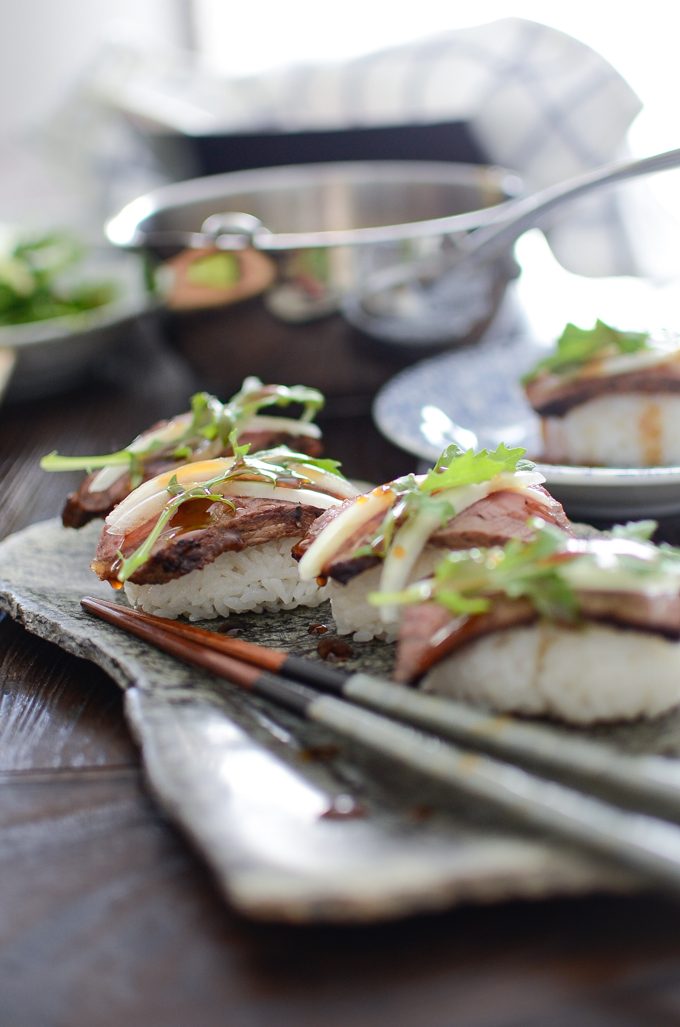 Beef Steak Sushi with teriyaki sauce is served on a stone platter.