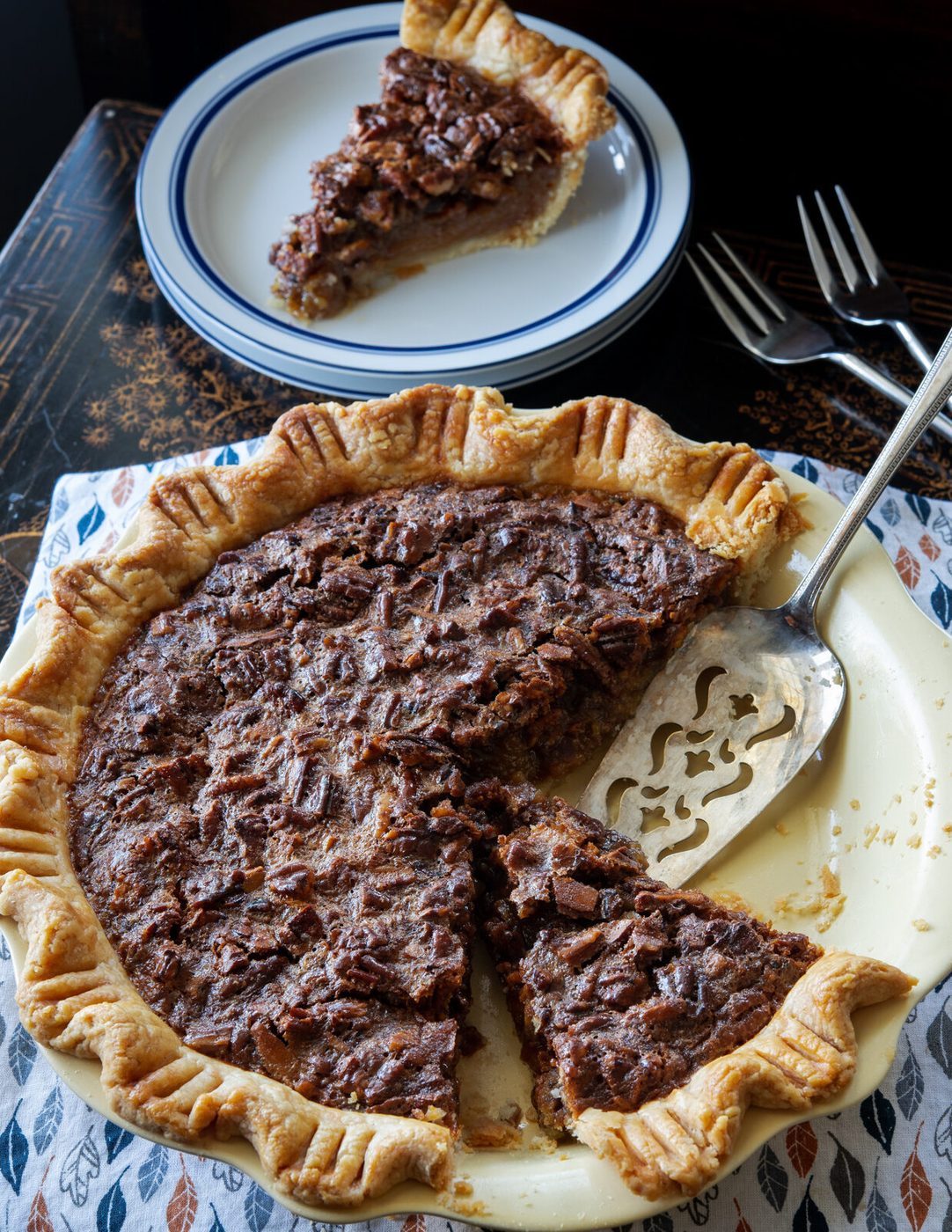 A slice of butterscotch pecan pie with flaky kitchen-made pie crust is ready to serve.