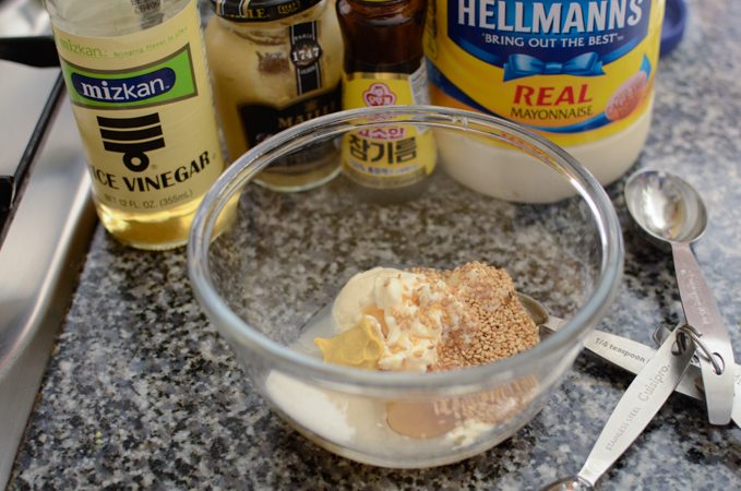 Salad dressing is combined in a bowl for ramen noodle salad.