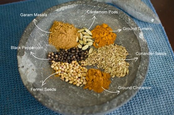 Curry spices are collected on a stone mortar to make Cape Malay chicken curry.