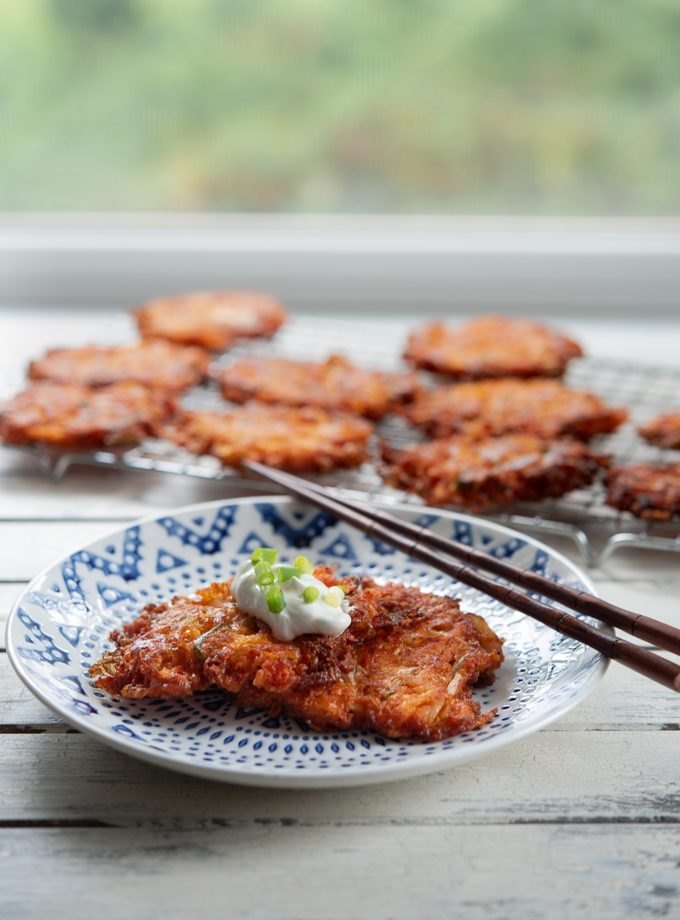 Cheesy Kimchi Potato Pancakes are garnished with a dollop of sour cream.