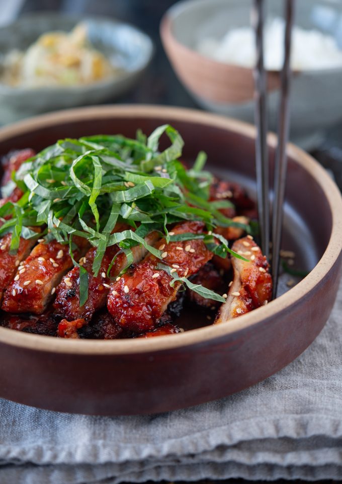 Close-up of chicken bulgogi topped with sliced perilla leaves and sesame seeds
