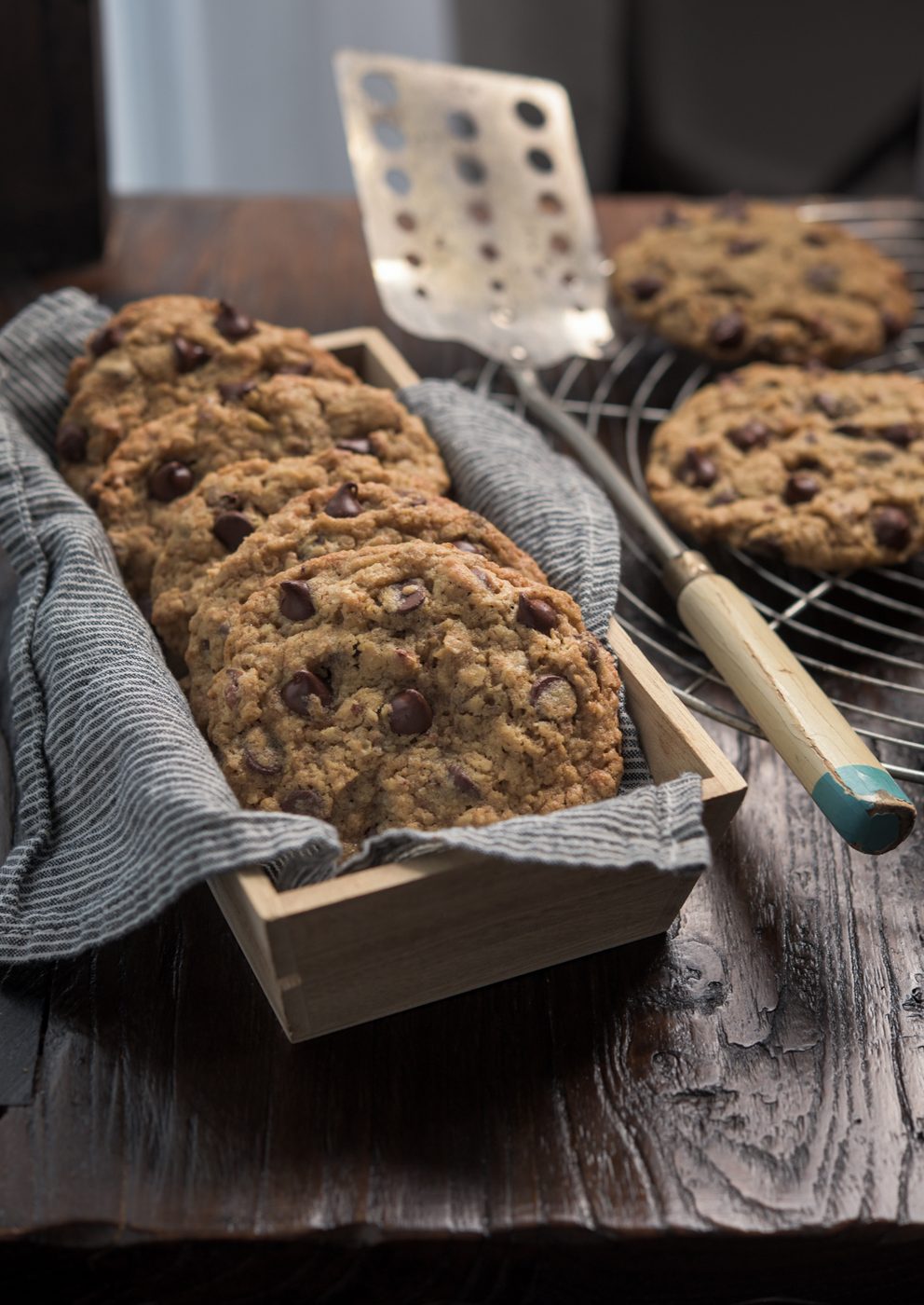 Wheat germ chocolate chip cookies are stacked together in a box.
