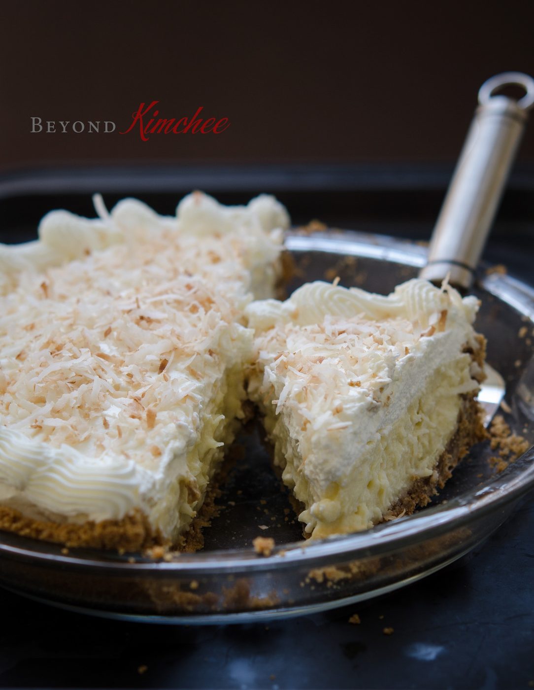 Coconut cream pie sliced in a pie dish.