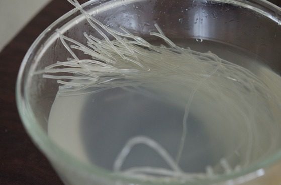 Korean glass noodles are soaked in water in a bowl.