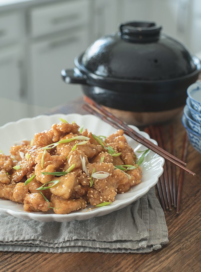 Crispy Chinese Lemon Chicken is garnished with green onion and chopsticks