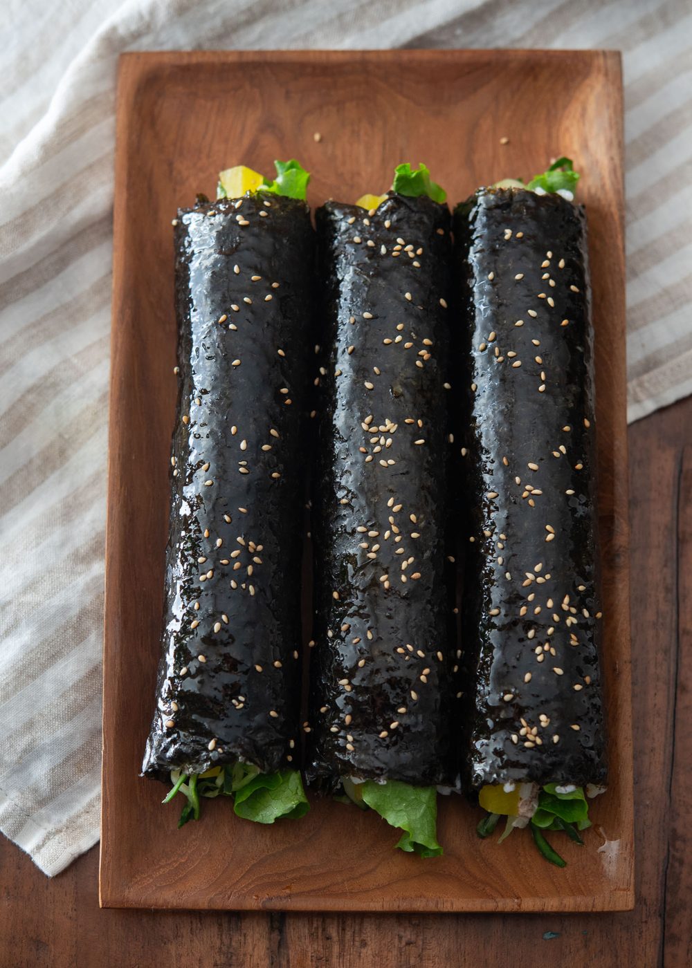 Freshly rolled tuna kimbap with sesame oil and sesame seed garnish