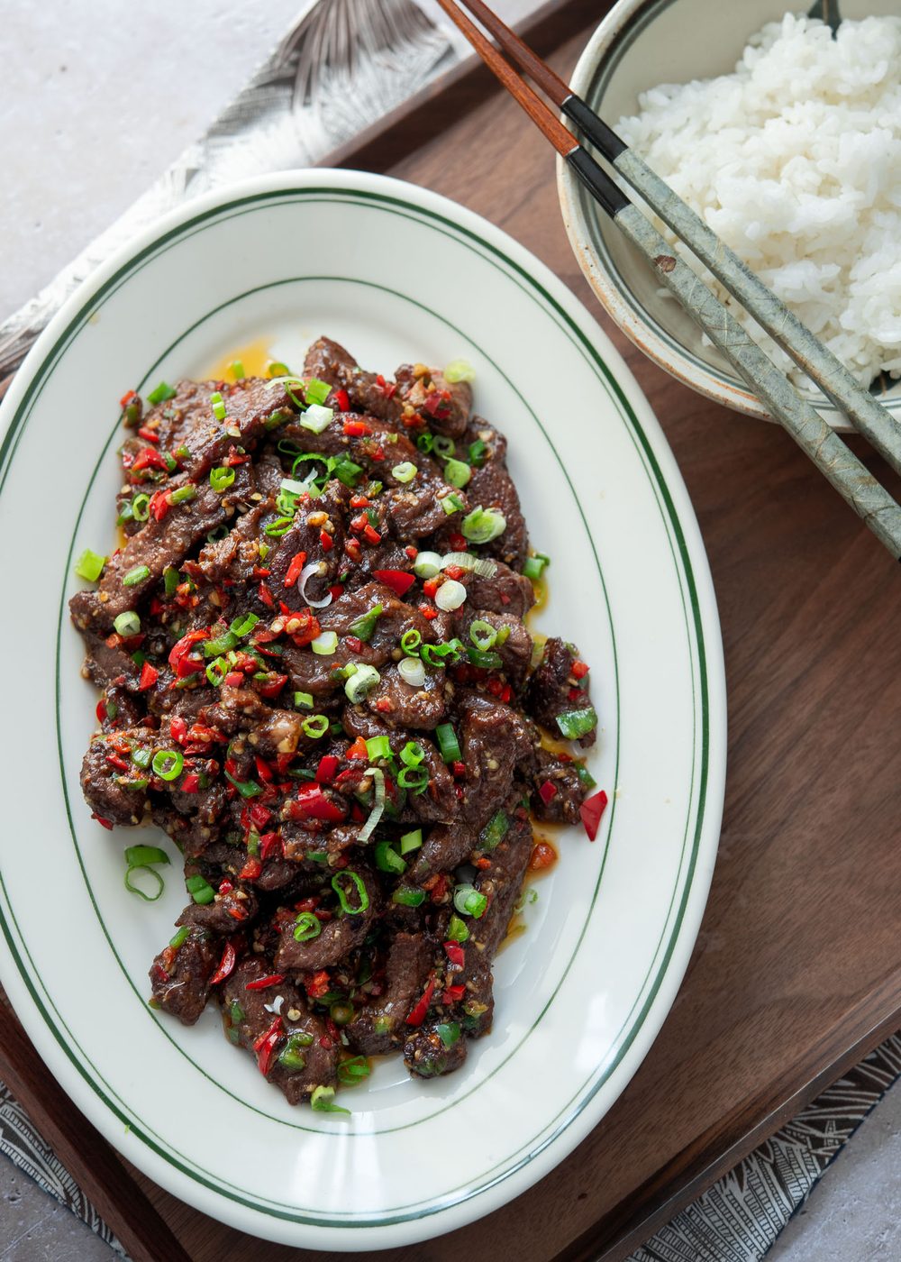 A plate of stir-fried cumin beef and a bowl of rice.
