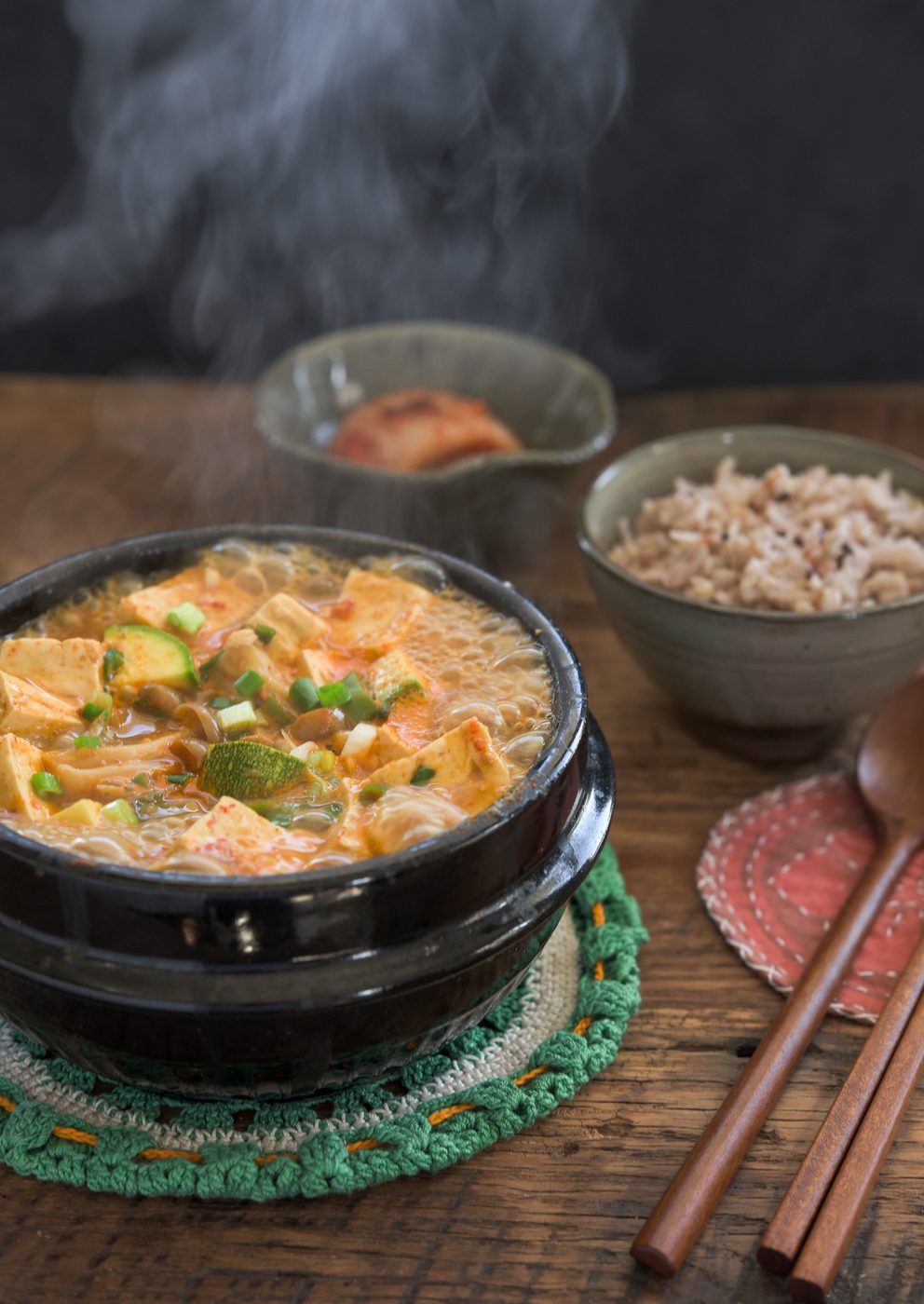 Classic Doenjang Jjigae (Korean Soybean Paste Stew) bubbling in a old-style stone pot.