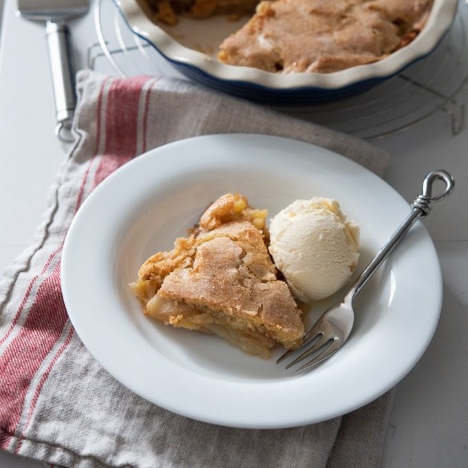 A piece of crustless apple pie served with vanilla ice cream.