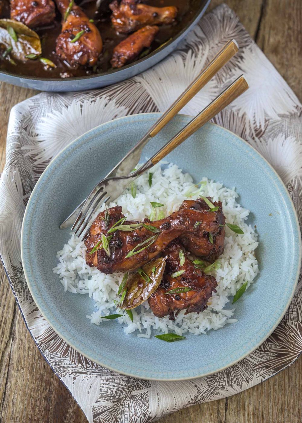 Bowl of old-style Filipino chicken adobo served with fluffy white rice.