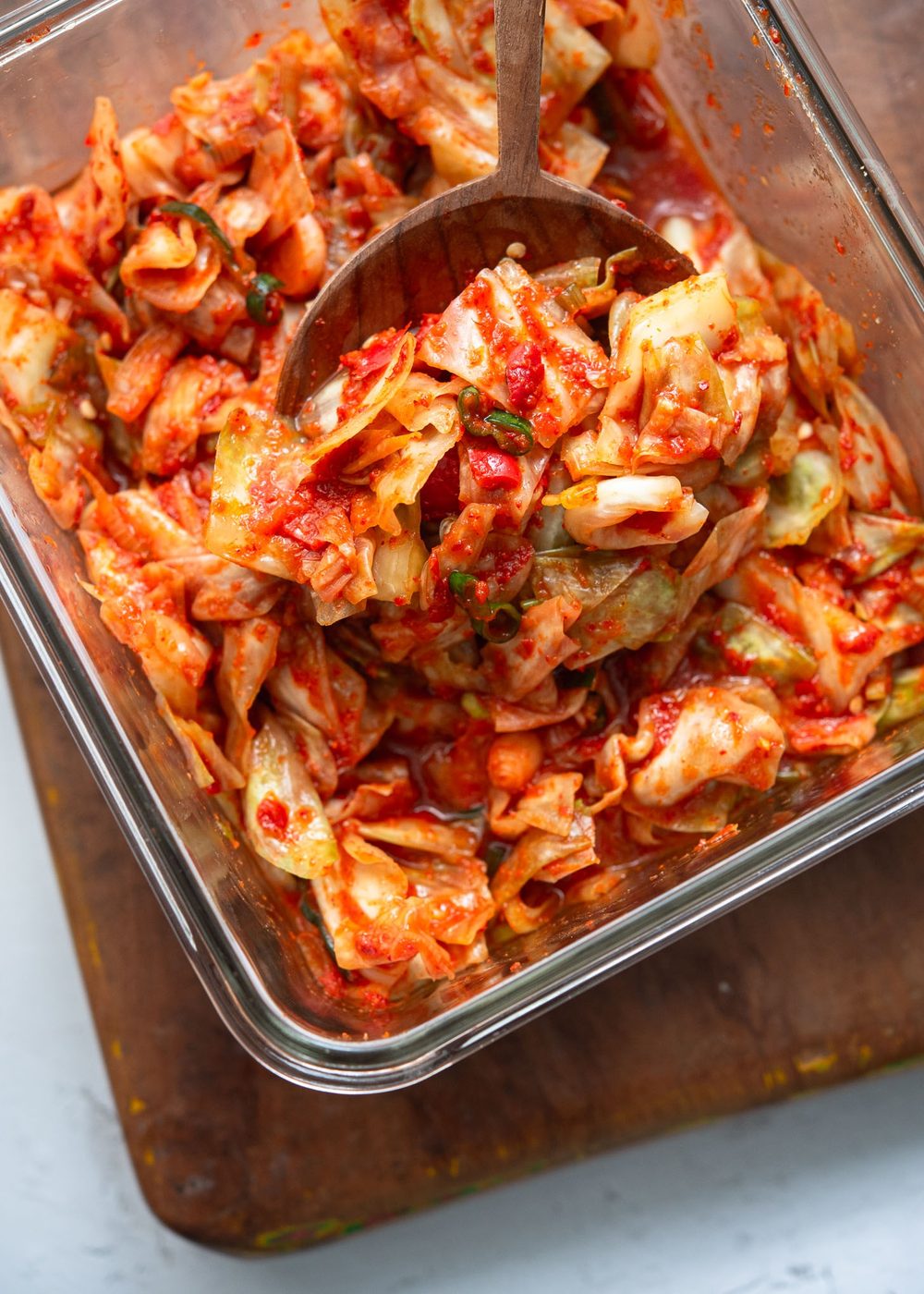 Green cabbage kimchi (yangbaechu kimchi) in a glass container.