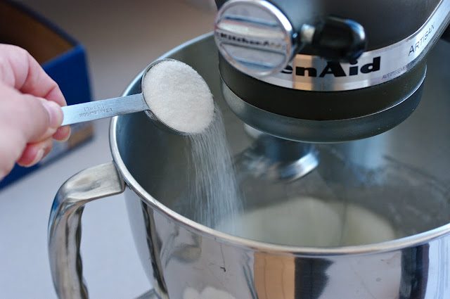A spoon of sugar added to wet ingredient mixture.