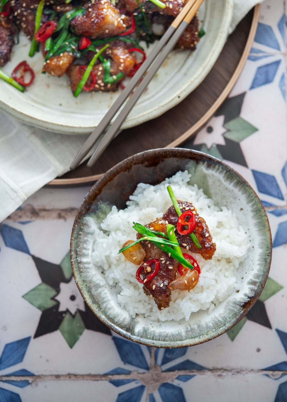 Steamed white rice topped with a piece of crispy honey garlic pork glazed with soy-honey sauce