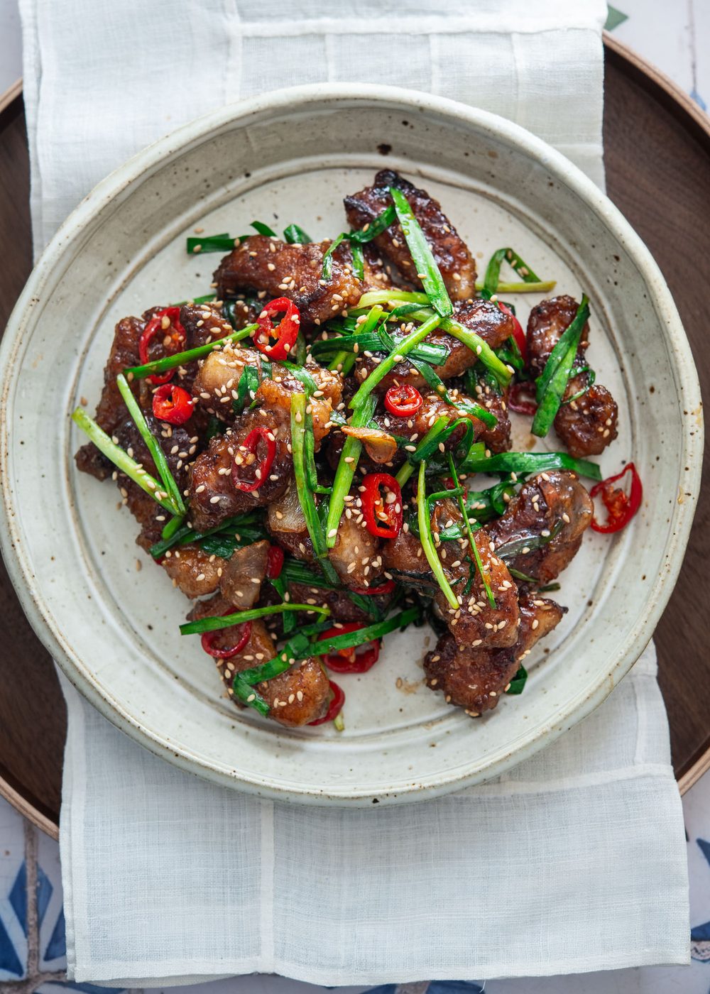 Honey garlic pork with chives in a serving plate.