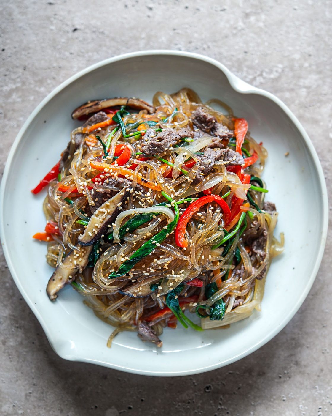 Japchae Korean glass noodles with beef and vegetables in a bowl