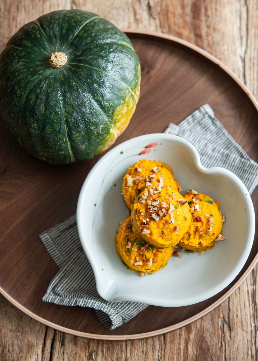 Mounds of Korean pumpkin salad served beside fresh kabocha squash