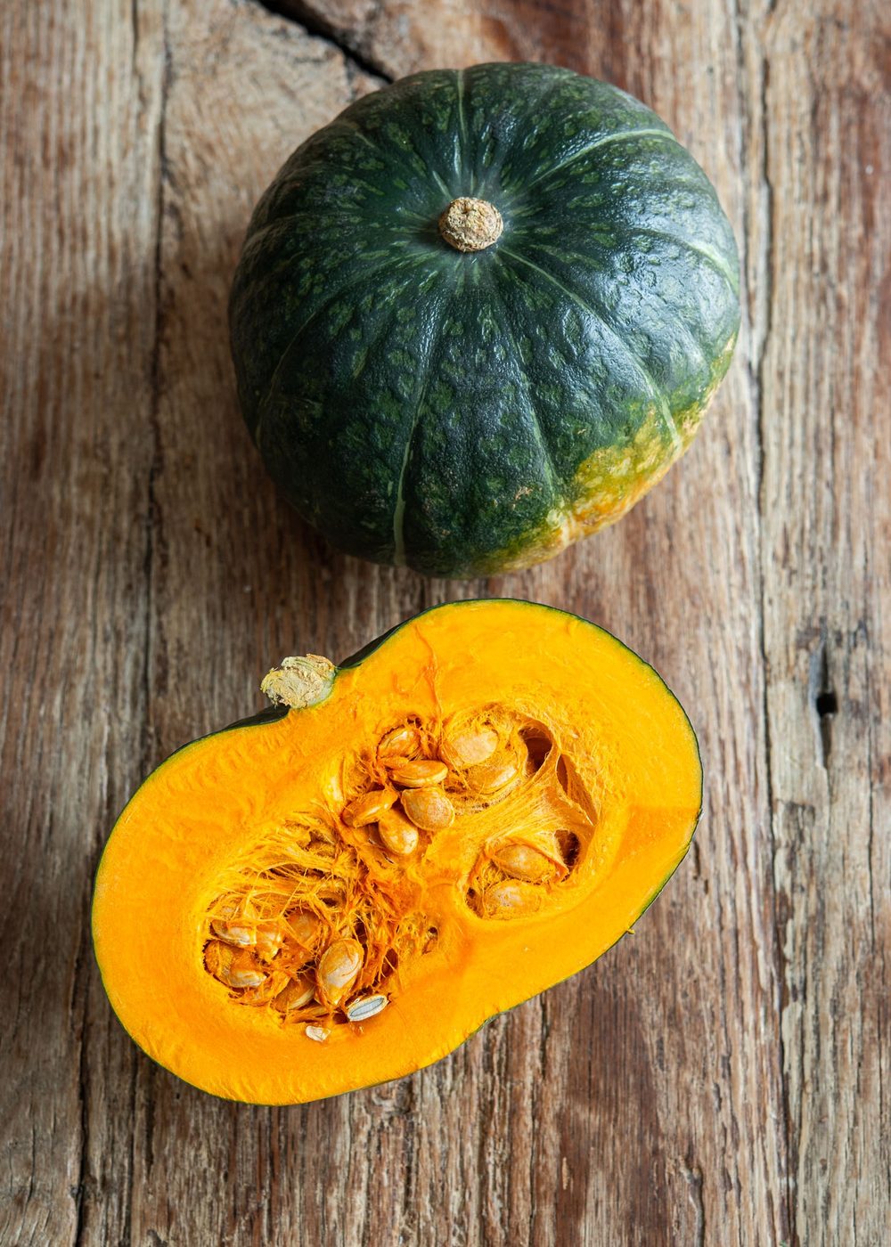 Halved kabocha pumpkin showing its golden interior and seeds