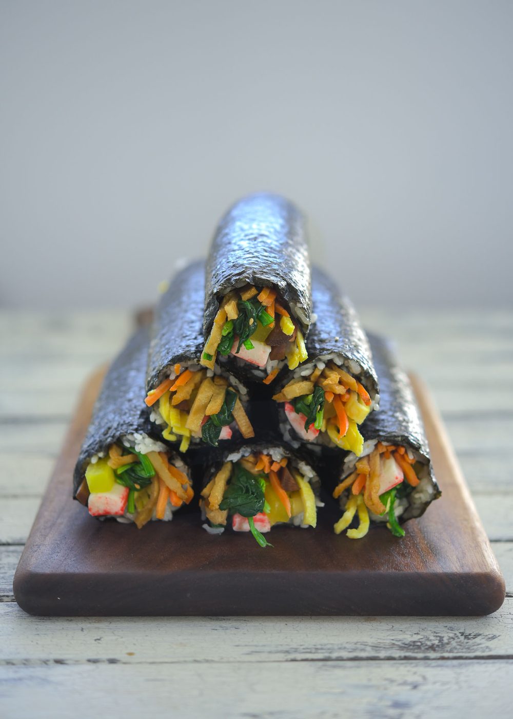 Whole Korean kimbap rolls arranged in a stack before slicing