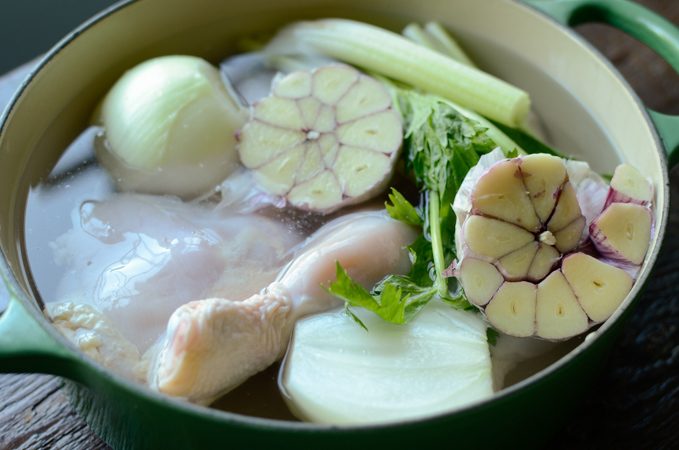 Chicken and aromatics in water in a pot to make stock.