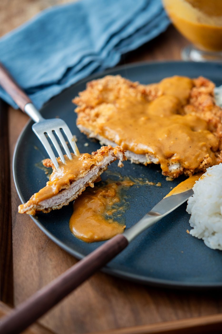 Thin Korean donkatsu pork cutlet sliced open with brown sauce