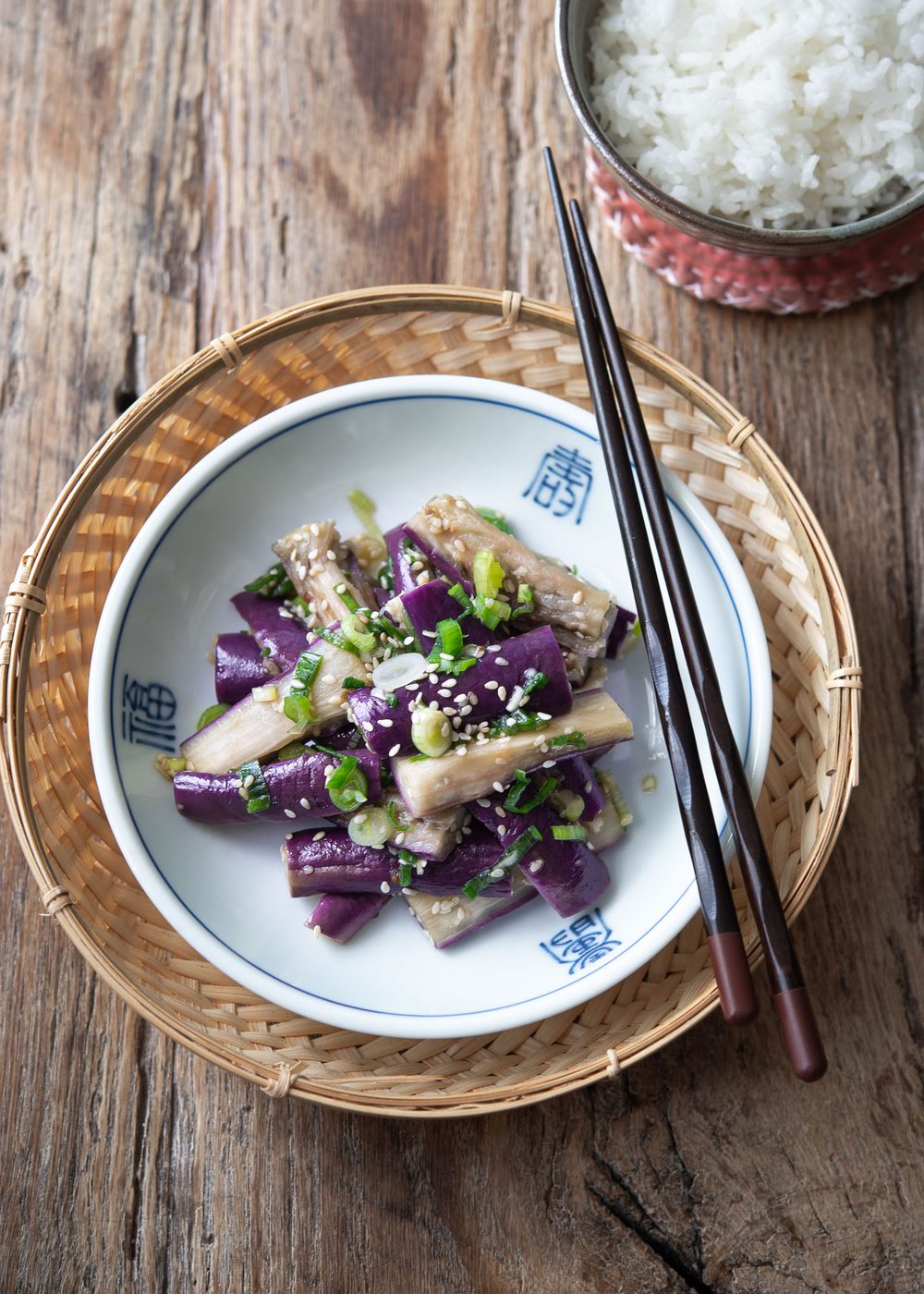 Korean eggplant side dish is presented in a small serving dish with chopsticks.