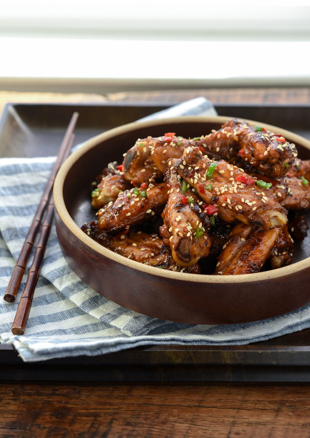 Korean honey garlic chicken wings with fresh chili garnish in a serving bowl