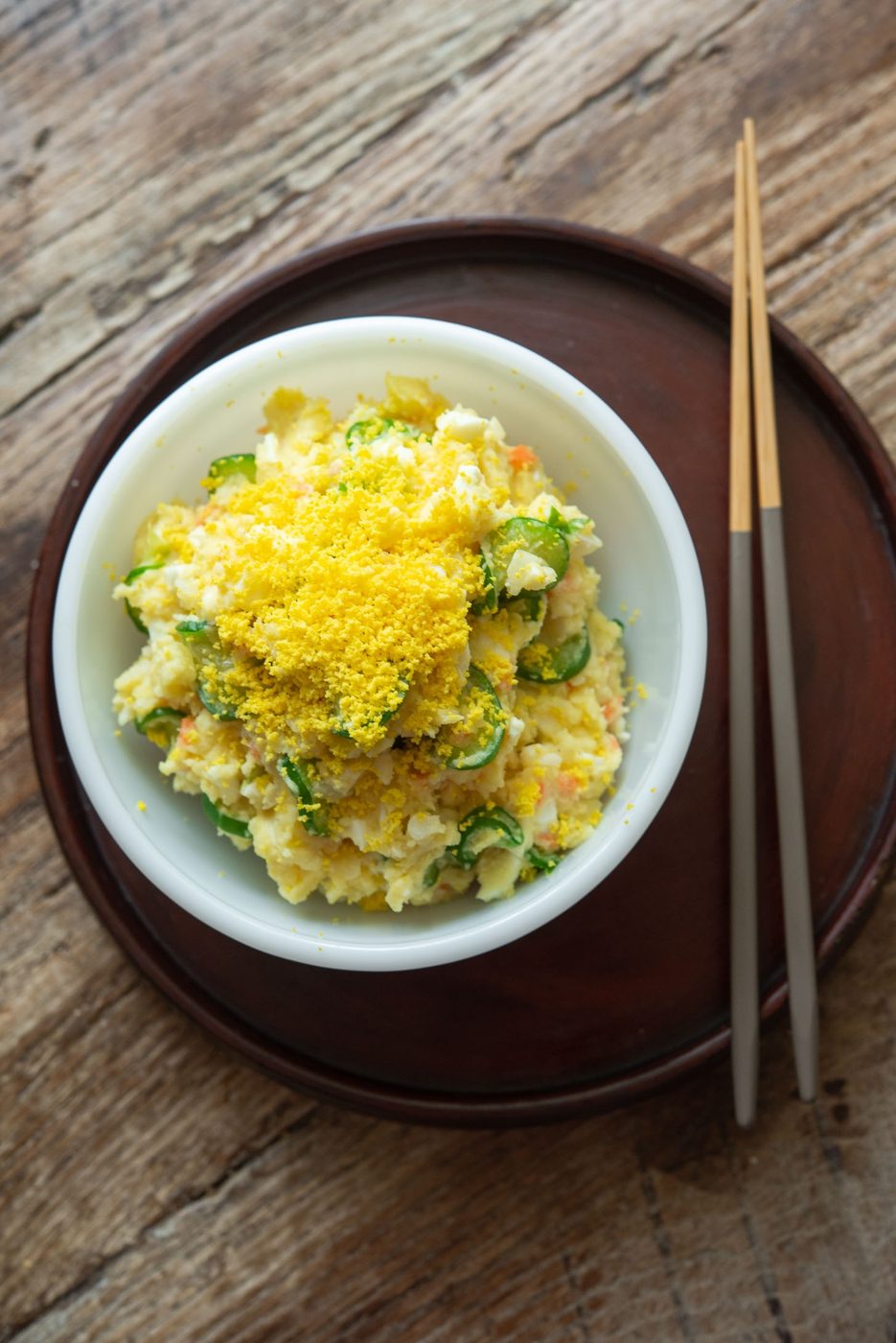 Korean potato salad in a bowl with chopsticks.