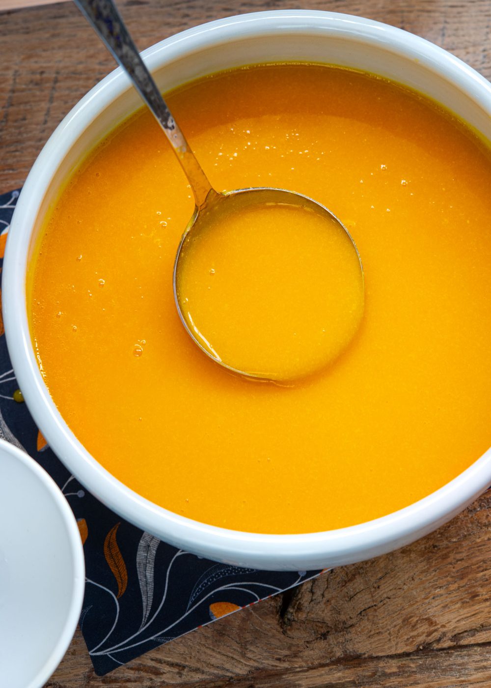 A ladle of Korean pumpkin porridge (hobakjuk) in a soup pot