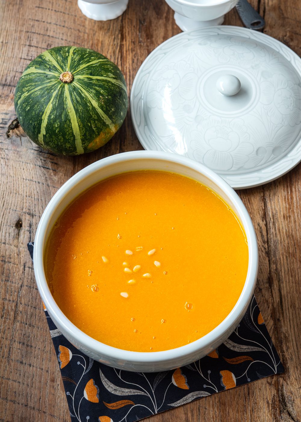 Korean pumpkin porridge is served in a large soup bowl with a lid.