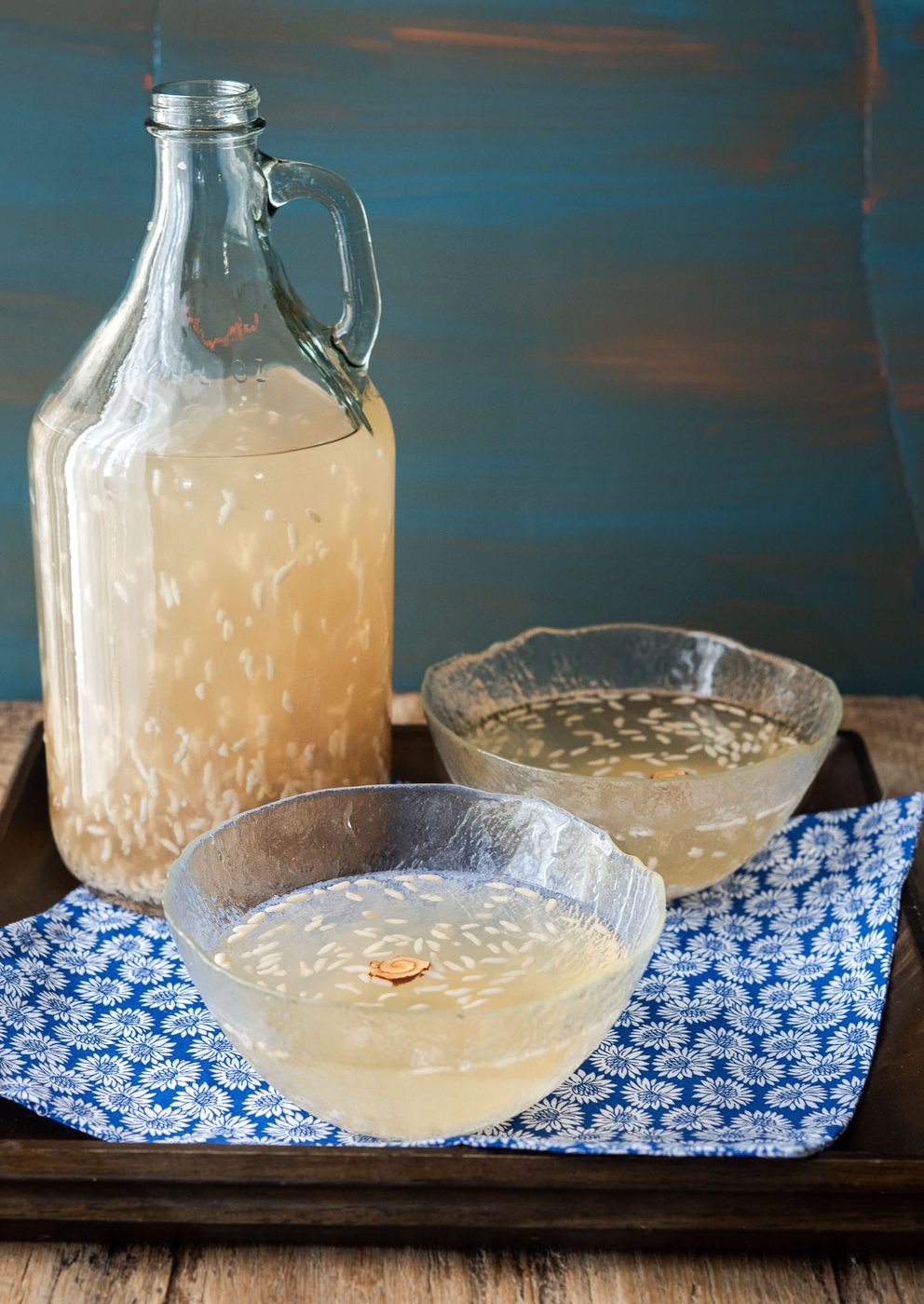 Two glass bowls of Korean rice punch garnished with rice grains.