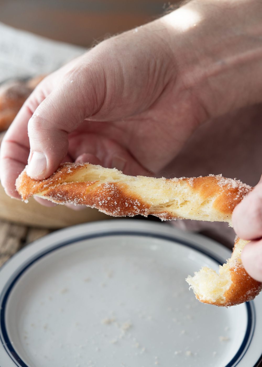 Korean kkwabaegi torn open by hand, revealing a crisp exterior and soft, fluffy inside