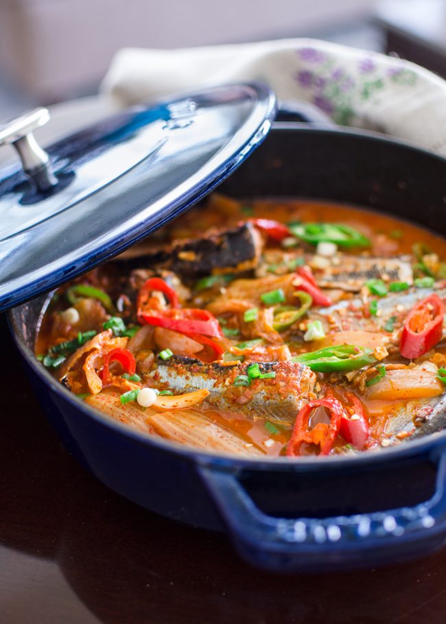Kimchi Jjigae is made with canned mackerel pike fish in a blue pot.
