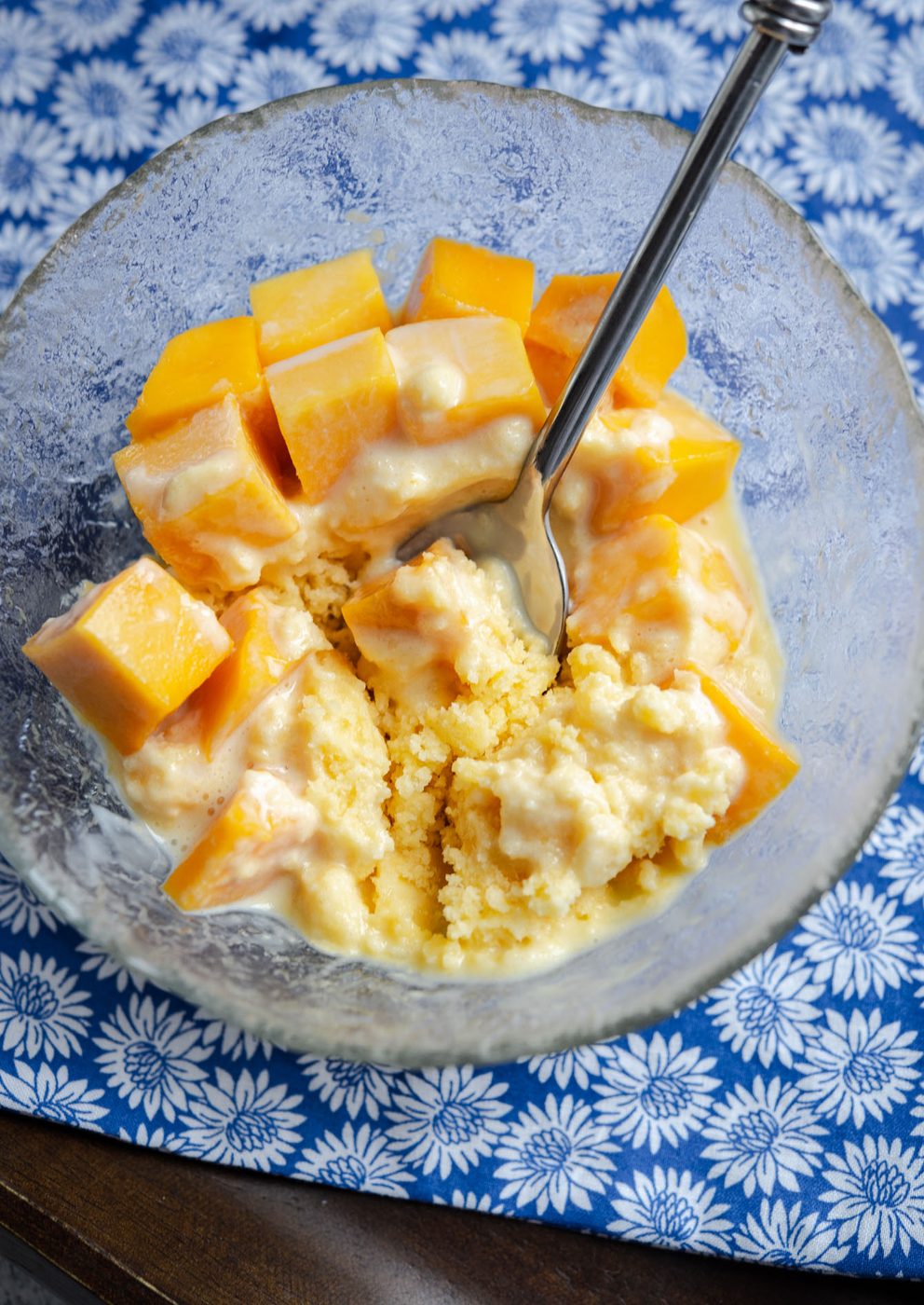 Shaved ice with fresh mango pieces in a bowl.