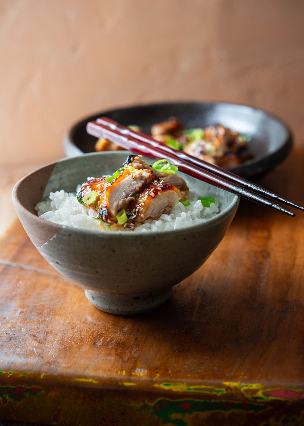 Bowl of rice topped with juicy miso chicken thighs and green onion