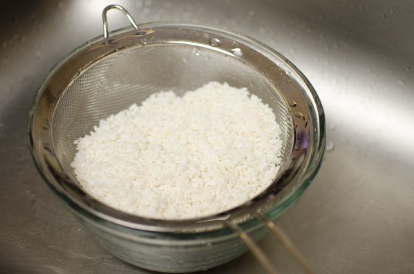 Rinsed rice in a strainer.