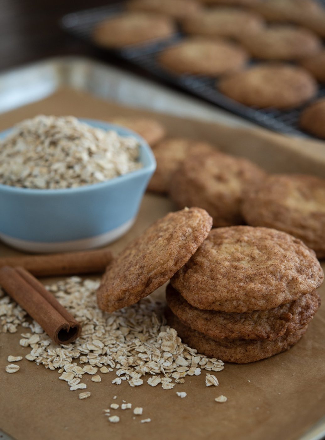 Oatmeal snickerdoodle cookies with a bowl of oats.