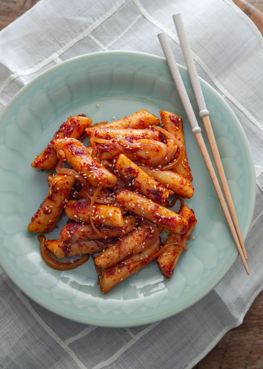 Spicy Korean stir-fried rice cakes served on a plate with chopsticks.