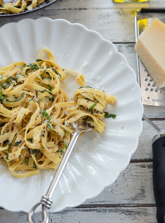 A fork twirling anchovy basil pasta.