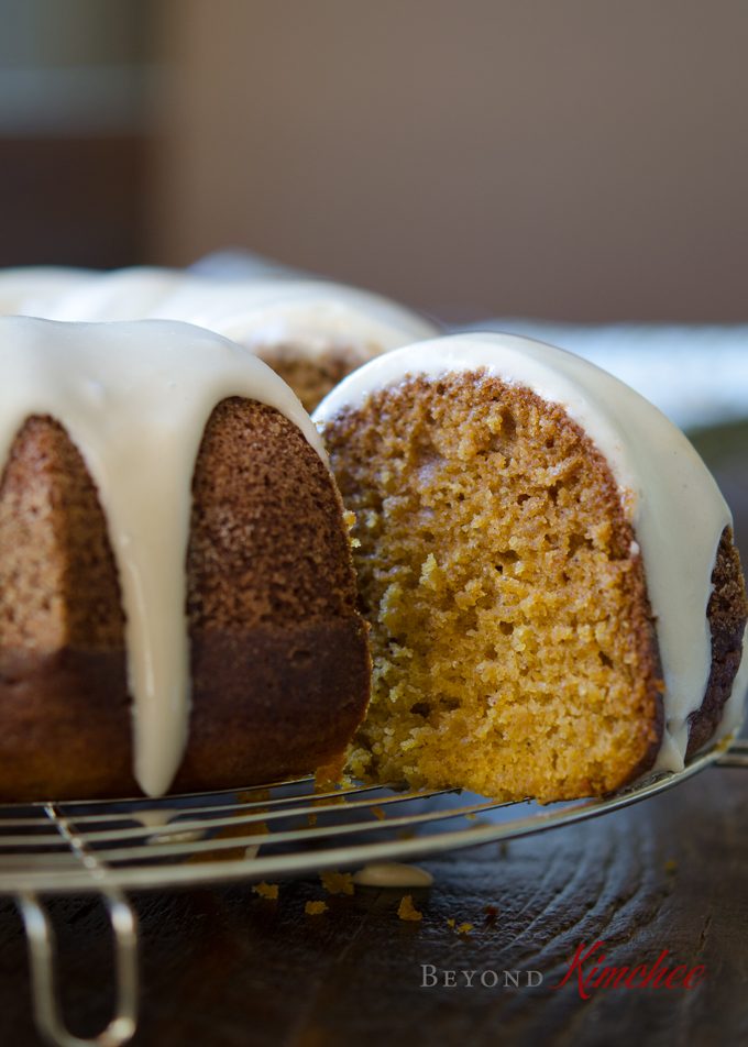 A slice of glazed pumpkin bundt cake with maple glaze has moist, tender crumbs.