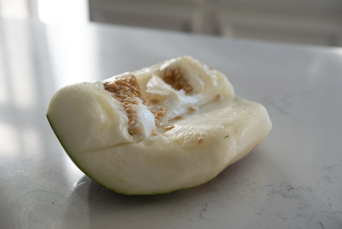 Winter melon chunk with seeds on a cutting board