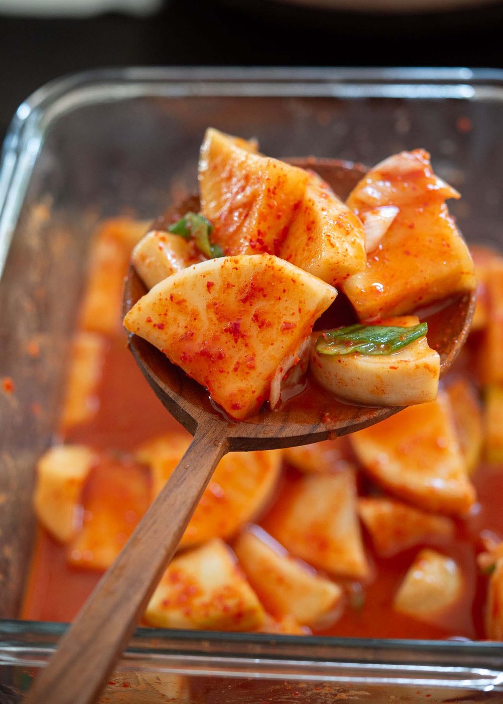 A ladleful of fermented radish kimchi ready to serve.