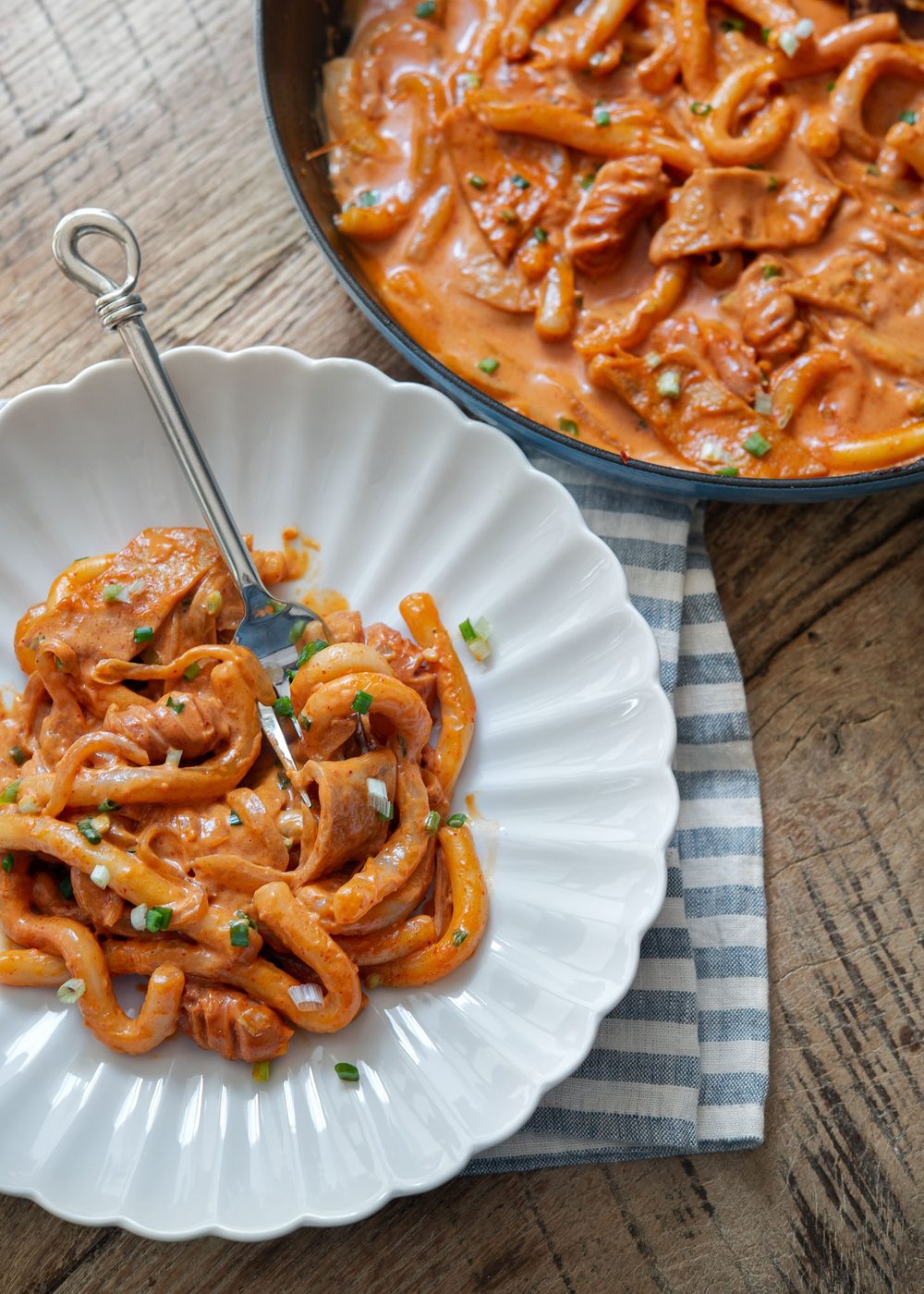 Rose tteokbokki plated on a white dish