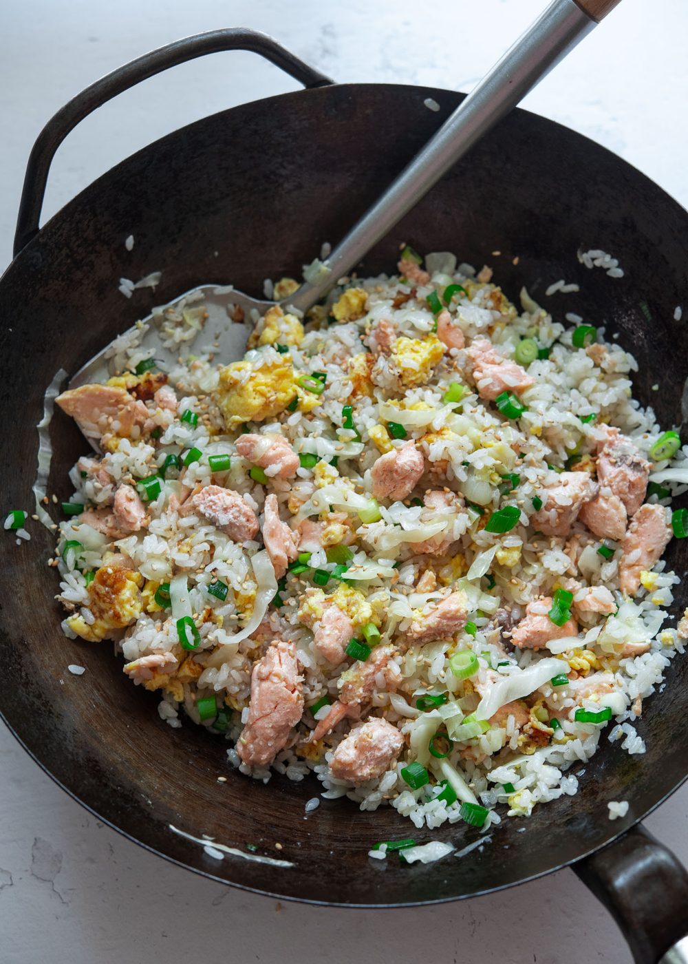 salmon fried rice with egg and cabbage finished cooking in a wok