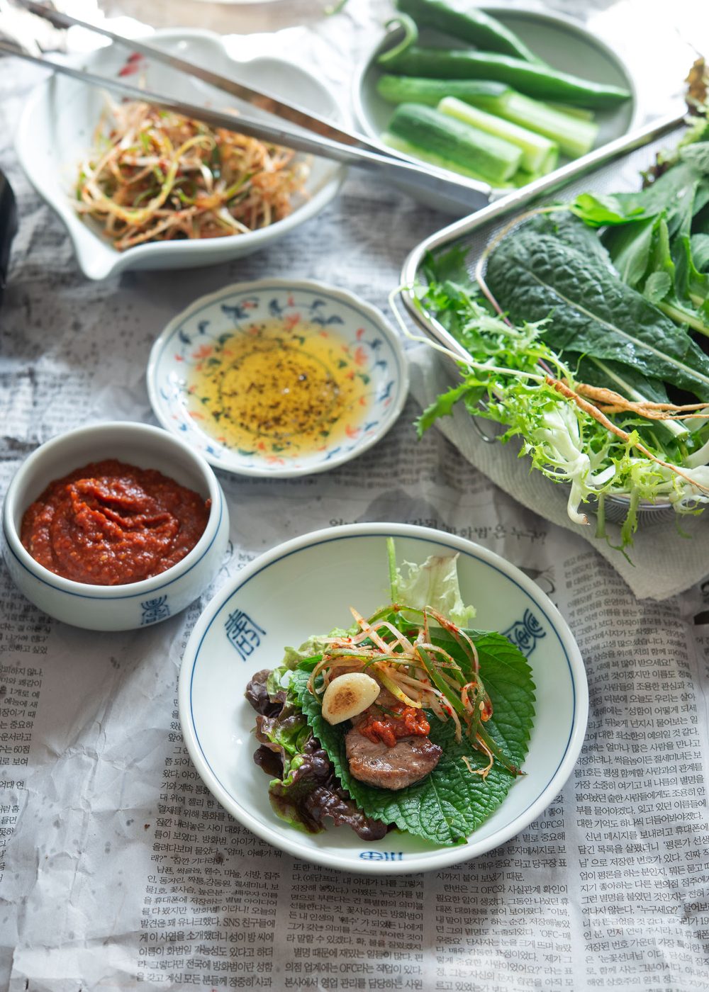 Grilled pork belly wrapped in lettuce with ssamjang and green onion salad